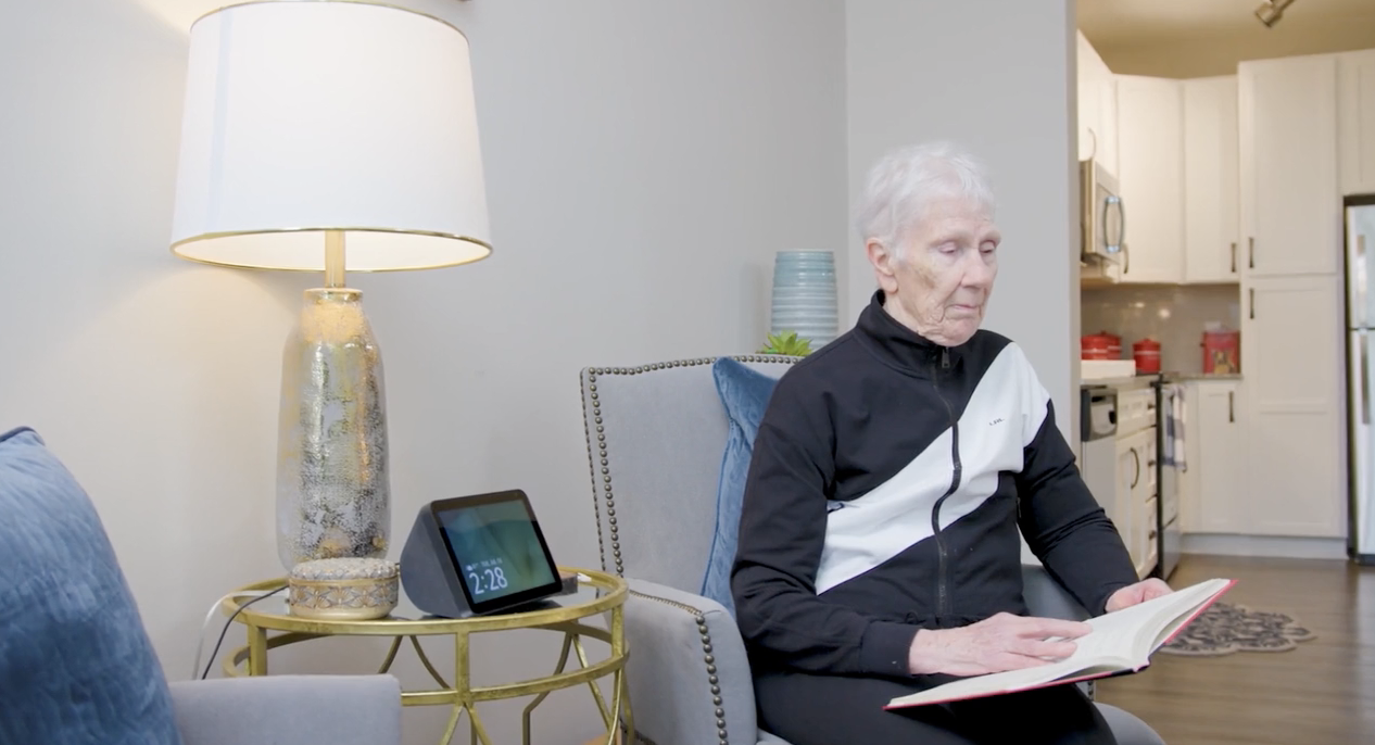 Older adults resident using an Amazon Echo Show while reading a book